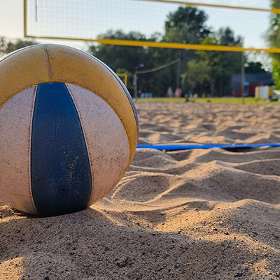 Volleyball on sand in front of net